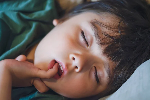 Kanepede uyuyan yüzlü çocuk, uyurken parmağını atına koyan çocuk, bahar veya yaz öğleden sonra şekerleme yapan yorgun çocuk, zihinsel sağlık çocukları konsepti.