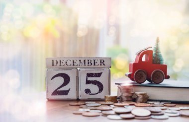 Tahta Noel takvimi. 25 Aralık 'ta yığınla bozuk para ve Noel ağacıyla kırmızı araba oyuncağı, Yeni Yıl için mali planlama para biriktirmek için yeni yıla kadar hazır, tatil geçmişi