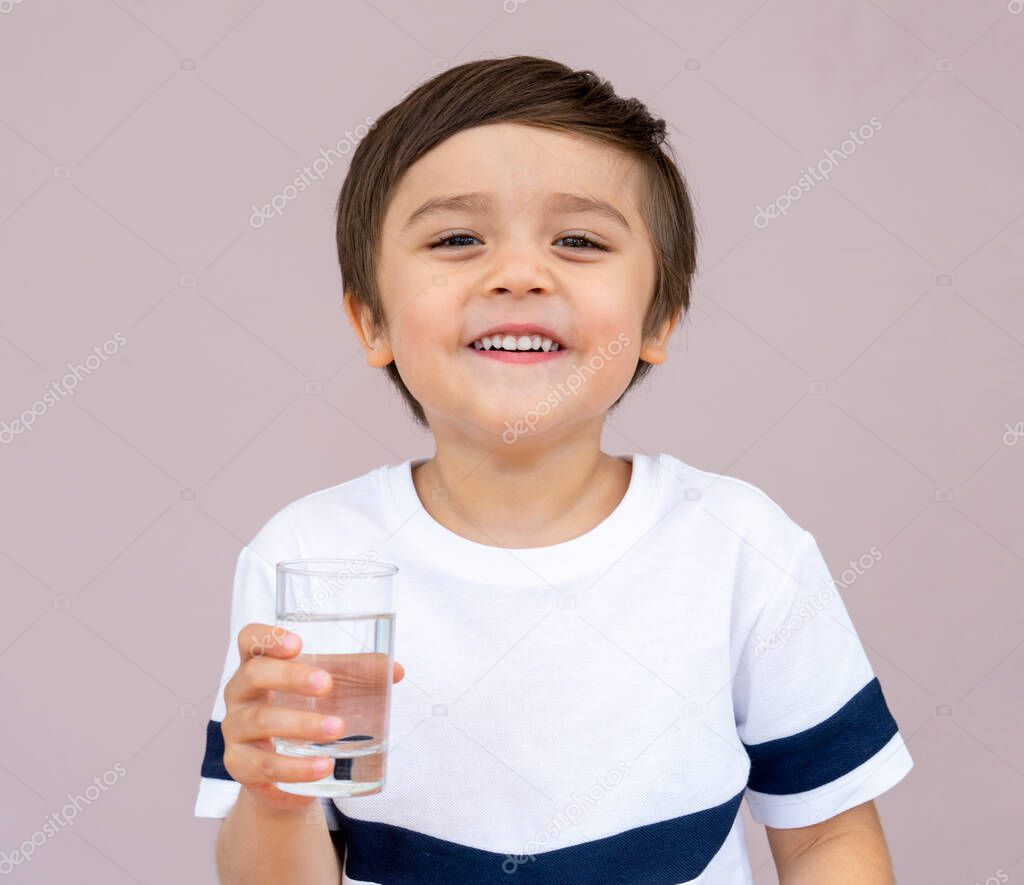 Thirsty cute boy drinking cold and clean water, Portrait of Caucasian toddler boy drinking glass of water,Healthy kid holding transparent glass,World Water day,Children Health care concept