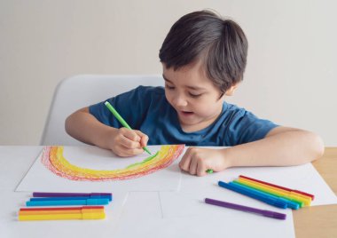 Kağıt üzerinde renkli kalem boyası kullanan çocuk, dijital tablet kullanarak gökkuşağı rengi hakkında bilgi arayan çocuk, koronavirüs önleme kavramı için evde eğitim sosyal medya kampanyası