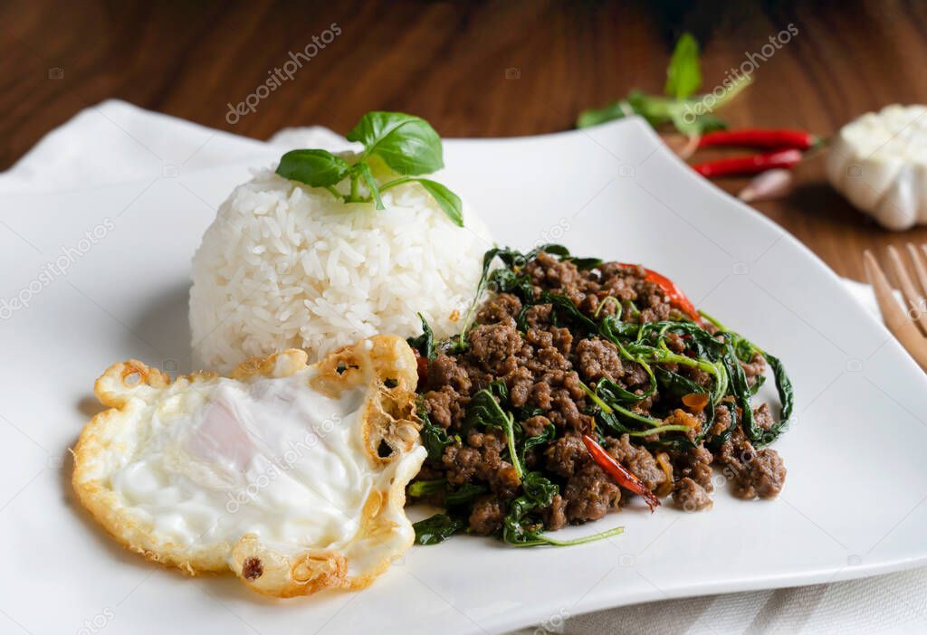 Top view of Homemade Stir fried minced pork with basil served with steamed jasmine rice and fired egg, Thai famous spicy food, Thai name is Pad kra pao Kai dow