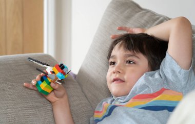 Kırpılmış mutlu çocuk kanepede uzanmış televizyon izlerken, Candid gülümseyen yüzü evde dinlenen pozitif çocuk vurdu, yeni normal yaşam tarzı kavramı.