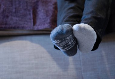 Açık saçık çorap giyen, kanepede oturan okul çocuklarının bacaklarının asılması farklı çoraplar giyer, okuldaki zorbalara karşı garip çoraplar giyilir.