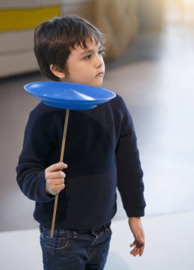 Çocuk dönen tabak oynamayı öğreniyor, okul öncesi okul çocuğu tahta direkte denge kuruyor, çocuklar içeride ve dışarıda çocuklar ve aileler için aktiviteler öğreniyor ve oynuyor.