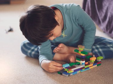 Aktif küçük çocuk inşaat plastik oyuncak bloklarıyla oynuyor, çocuk oyun odasında renkli oyuncaklar oynuyor, bebek gelişimi konsepti...