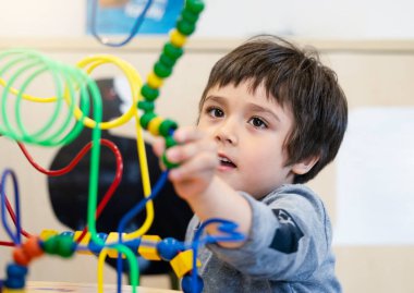 Çocuk 'un evdeki oyun odasında renkli oyuncaklar oynaması, Çocuk' un anaokulunda eğitici oyuncaklarla oynaması. Yürüyen çocuk geliştirme kavramı