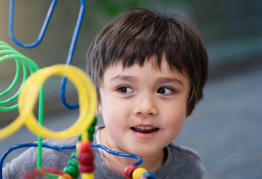 Çocuk 'un evdeki oyun odasında renkli oyuncaklar oynaması, Kid' in anaokulunda eğitici oyuncaklarla oynarken gülümseyen yüzüyle bakması.. 