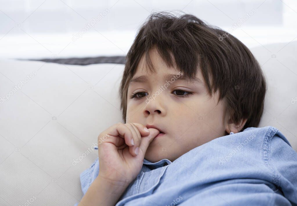 Portrait of little boy biting his finger nails while watching TV, Childhood and family concept, Emotional Child portrait.
