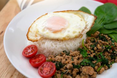 Ev yapımı kıyma ve fesleğenli fesleğen, haşlanmış yasemin pilavı ve Tayland usulü ünlü baharatlı yemek Tayland usulü kra pao Kai dow.