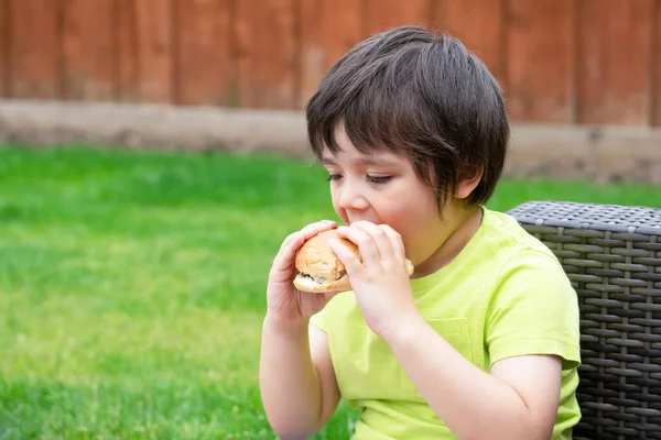 Mignon Enfant Âge Préscolaire Heureux Manger Hamburger Assis Dans Jardin — Photo