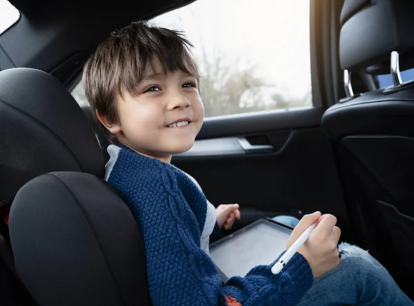 자동차 뒷좌석에 태블릿 컴퓨터 사용하는 스마트 그림을 그리는 자동차 여행에서 — 스톡 사진