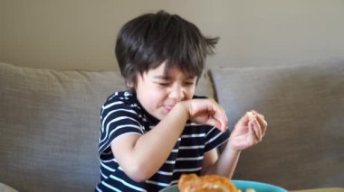 Sağlıklı çocuk kahvaltı yaparken dilimlenmiş limon ya da limon tadı alıyor..