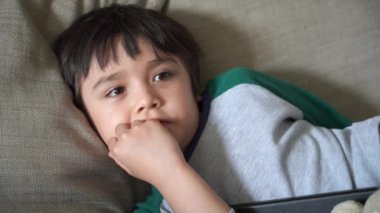 Candid, mutlu çocuğu kanepede uzanıp oturma odasında televizyon izlerken, Portre Çocuk 'u hafta sonları evde dinlenirken çekti. Pozitif çocuk konsepti