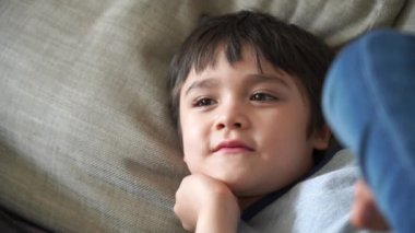 Candid, mutlu çocuğu kanepede uzanıp oturma odasında televizyon izlerken, Portre Çocuk 'u hafta sonları evde dinlenirken çekti. Pozitif çocuk konsepti