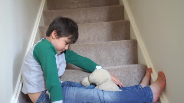 可爱男孩坐在地毯楼梯上玩玩具熊的肖像 可爱的孩子玩玩具和在家里放松的肖像 积极的孩子概念 — 图库视频影像