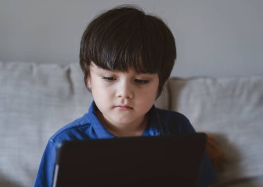 Okul çocuğunun ödevi için tablet kullanması, çocuğun düşünen yüzüyle dijital tablete bakması, küçük çocuğun dokunmatik kağıtta çizgi film izlemesi, şimdi normal hayatın internetten öğrenmesi, uzaktan eğitim alması.