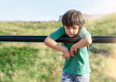 Yalnız çocuğun portresi, parkta yalnız başına oynayan üzgün çocuk, düşünen yüzüyle oyun alanında birini bekleyen zavallı çocuk..