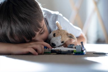 Gizli çekim oyuncaklarla oynarken uyku, Seçici odak Chiled öğleden sonra bir şekerleme yapıyor, küçük çocuk dinlenme düşük görüş güneşli bir gün bulanık gün ile oturma odasında dinleniyor yaz