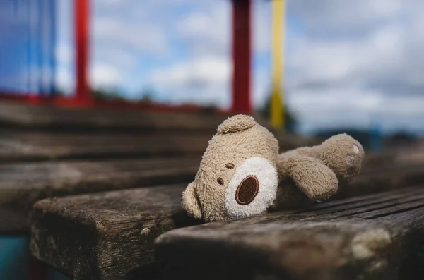 어두운 놀이터의 다리에 길잃은 인형외로운 얼굴의 공원에 장난감이나 아동의 — 스톡 사진