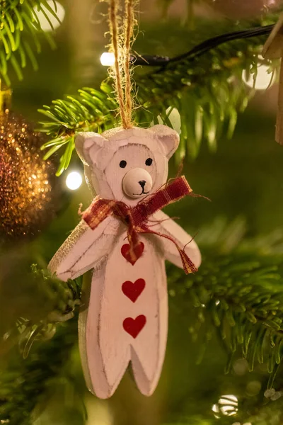Ağaçtan sarkan beyaz tahta bir ayı şekilli Noel ağacı süslemesi.