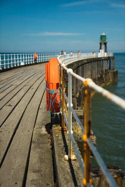 Kuzey Yorkshire, Whitby 'deki rıhtımda ön planda turuncu bir can simidi var.