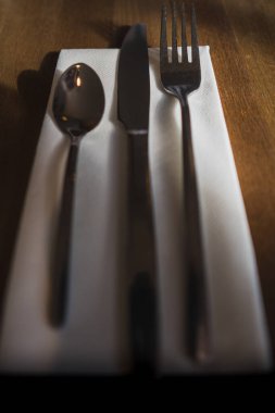 Çatal bıçak takımı, çatal bıçak seti, beyaz bir peçeteye oturmuştu.