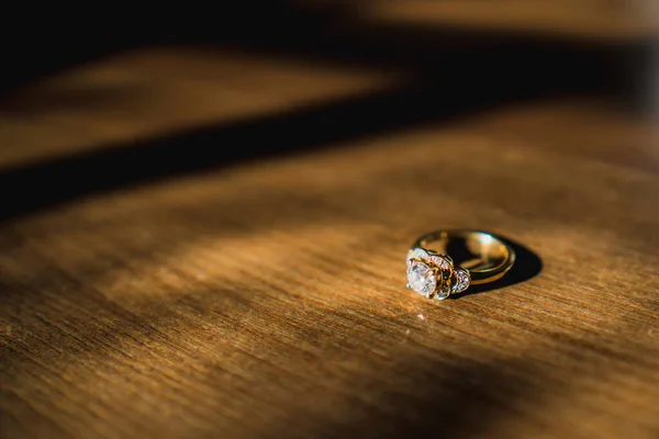 Ein Goldener Diamant Verlobungsring Saß Bei Tageslicht Auf Einem Holztisch — Stockfoto