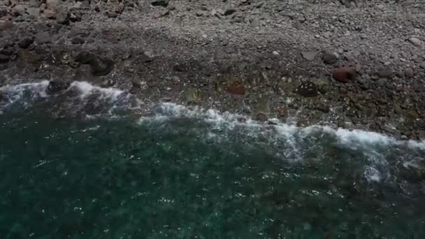 Запись беспилотника над берегом, наблюдающего, как волны разбиваются о скалы — стоковое видео