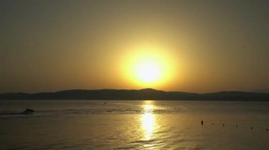 Yunanistan 'ın Skiathos kentinde gün batımında bir jet ski kayakçısının zamanlanmış videosu