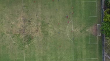 Aşağıya bakan drone görüntüleri futbol sahasında top oynadığını gösteriyor. Karang Kotagede Uluslararası Alanı 'nda. Yüksek kalite 4k görüntü