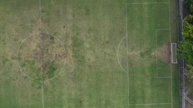 Aşağıya bakan drone görüntüleri futbol sahasında top oynadığını gösteriyor. Karang Kotagede Uluslararası Alanı 'nda. Yüksek kalite 4k görüntü