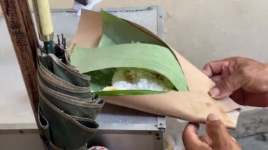 Putu Bambu sıcak, tatlı, buharda pişmiş, tatlı palmiye şekerli, geleneksel olarak bir bambu tüpünde buharda pişirilmiş ve rendelenmiş hindistancevizi ve biraz şekerli pirinç keki.. 