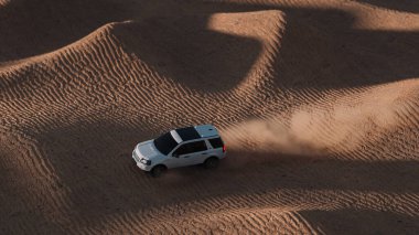 Dubai, BAE - 10 Haziran 2020: çölde giden SUV 'nin hava görüntüsü. Çöl kumullarında yol safarisi