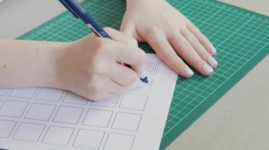 Genç kız kaligrafi okuyor. Bir kağıt parçasına çizgiler çizmek. Ev eğitimi kavramı