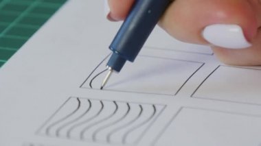 Kaligrafi eğitim süreci. Genç kız kağıda çizgiler çiziyor. Çalışma teması