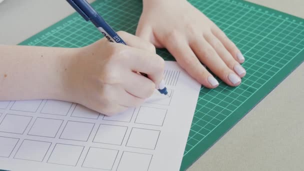 Junges Mädchen studiert Kalligraphie. Linien auf einem Blatt Papier zeichnen. Heimatstudienkonzept — Stockvideo