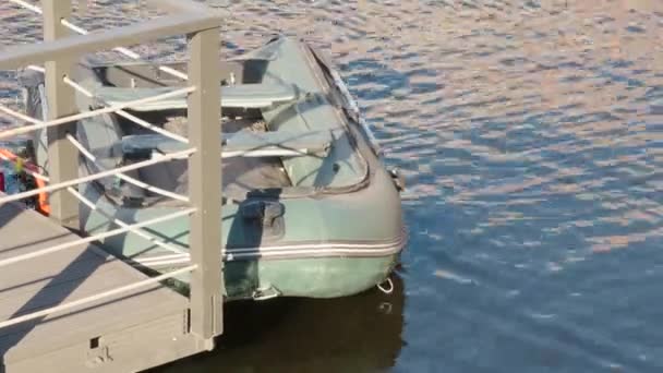 Un petit bateau gonflable ancré au quai. Bateau en caoutchouc sur l'eau. Thème pêche — Video