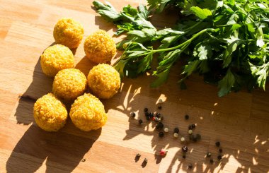 Falafel, İsrail 'in otantik yiyeceği. Tahta masada maydanoz ve biberli taze ev yapımı falafeller. Sağlıklı beslenme konsepti. İçindekiler üst görünüm. 