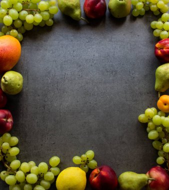 Koyu arkaplanda renkli meyve çerçevesi. Yaz meyveleri fotokopi alanı ile üst görünüm fotoğrafı. 