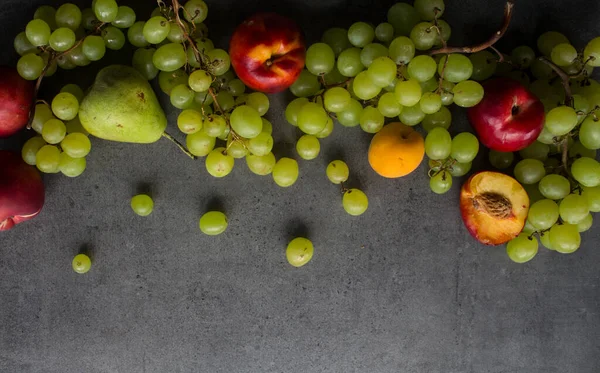 色彩艳丽的多汁水果边沿 新鲜的夏季水果顶部视图照片 带有复制空间的深灰色背景 — 图库照片