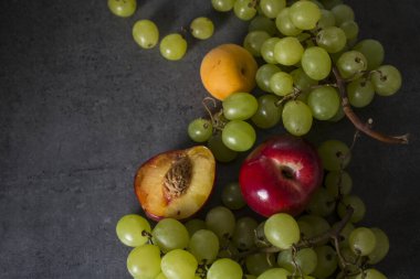Yaz meyveleri renkli sınırlar. Sulu üzüm ve nektarin üst görünüm fotoğrafı. Kopyalama alanı olan koyu gri arkaplan. 