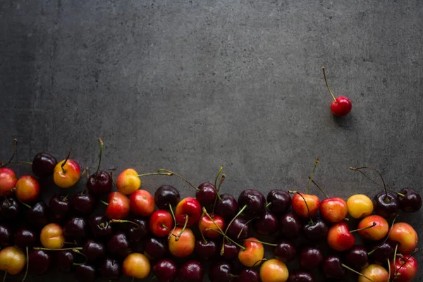 美丽多汁的樱桃边框 带有复制空间的深灰色纹理背景 夏天的水果结冰了 健康饮食概念 — 图库照片
