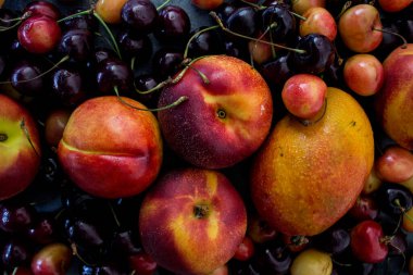 Canlı yaz meyveleri ve meyveleri kapanış fotoğrafı: taze kirazlar, mango ve nektarinler. Sağlıklı beslenme konsepti. Detoks diyeti. 