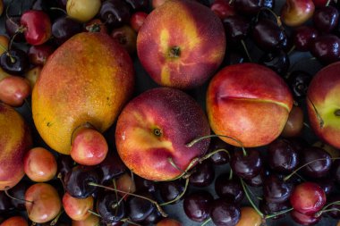 Canlı yaz meyveleri ve meyveleri kapanış fotoğrafı: taze kirazlar, mango ve nektarinler. Sağlıklı beslenme konsepti. Detoks diyeti. 