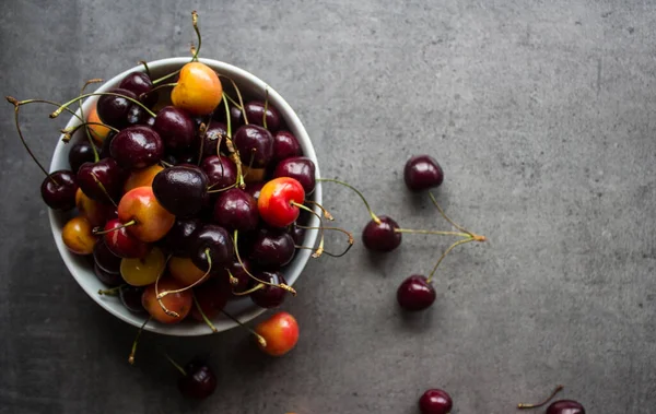 桌上放着甜樱桃 灰色混凝土背景 有复制空间 多汁的夏季浆果顶视图照片 健康饮食概念 — 图库照片