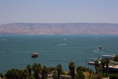 Denizde bir şehir. Mavi gökyüzü, ufuktaki tepeler ve sakin Akdeniz suyu. Ortadoğu doğası. İsrail yaz manzarası.