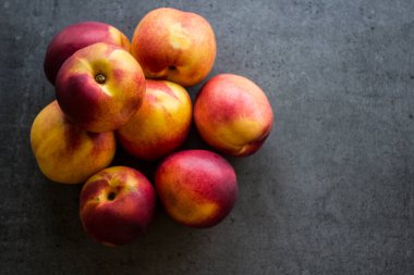 Masada taze nektarinler. Sulu yaz meyveleri fotoğrafı kapatır. Fotokopi alanı olan koyu gri bir arkaplan. Sağlıklı yeme kavramı. 