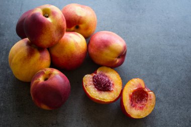 Masada taze nektarinler. Sulu yaz meyveleri fotoğrafı kapatır. Fotokopi alanı olan koyu gri bir arkaplan. Sağlıklı yeme kavramı. 