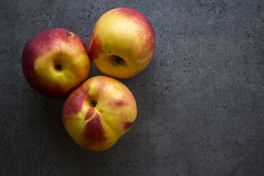 Masada taze nektarinler. Sulu yaz meyveleri fotoğrafı kapatır. Fotokopi alanı olan koyu gri bir arkaplan. Sağlıklı yeme kavramı. 