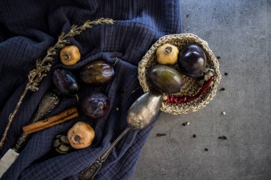 Taze erikler, kurutulmuş otlar ve lacivert kumaşta gümüş kaşıkla dolu bir hayat. Farklı nesnelerin üst görünüm fotoğrafı. Ağustos Renkleri.